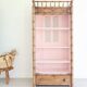 Library, old wooden cabinet imitating bamboo painted in pink