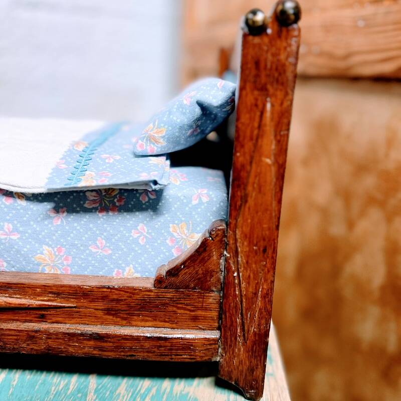 Old doll's bed in varnished wood
