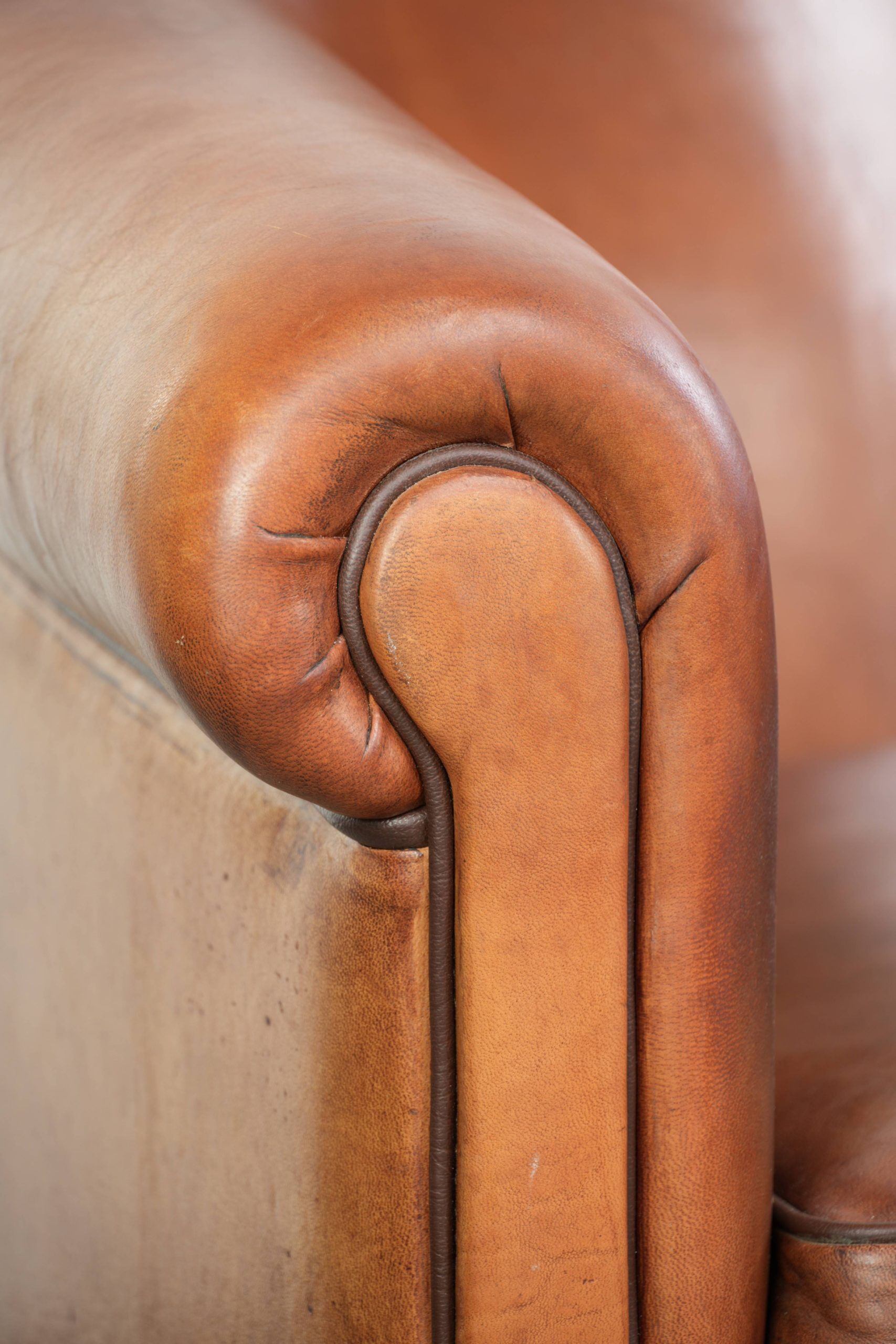 Vintage sheepskin club armchair with a warm colour scheme with black piping