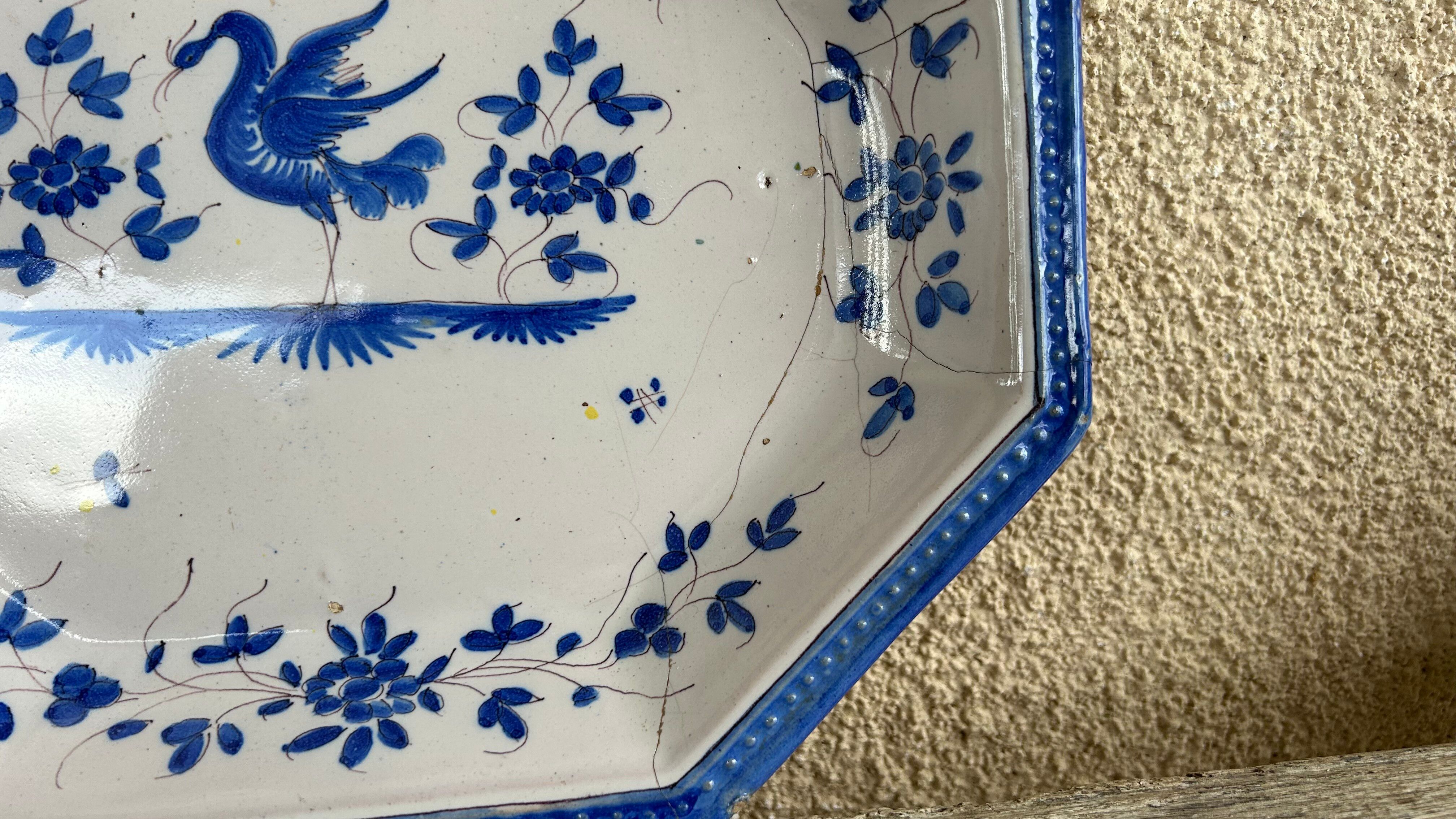 Antique octagonal plate in blue and white pottery with bird decoration.