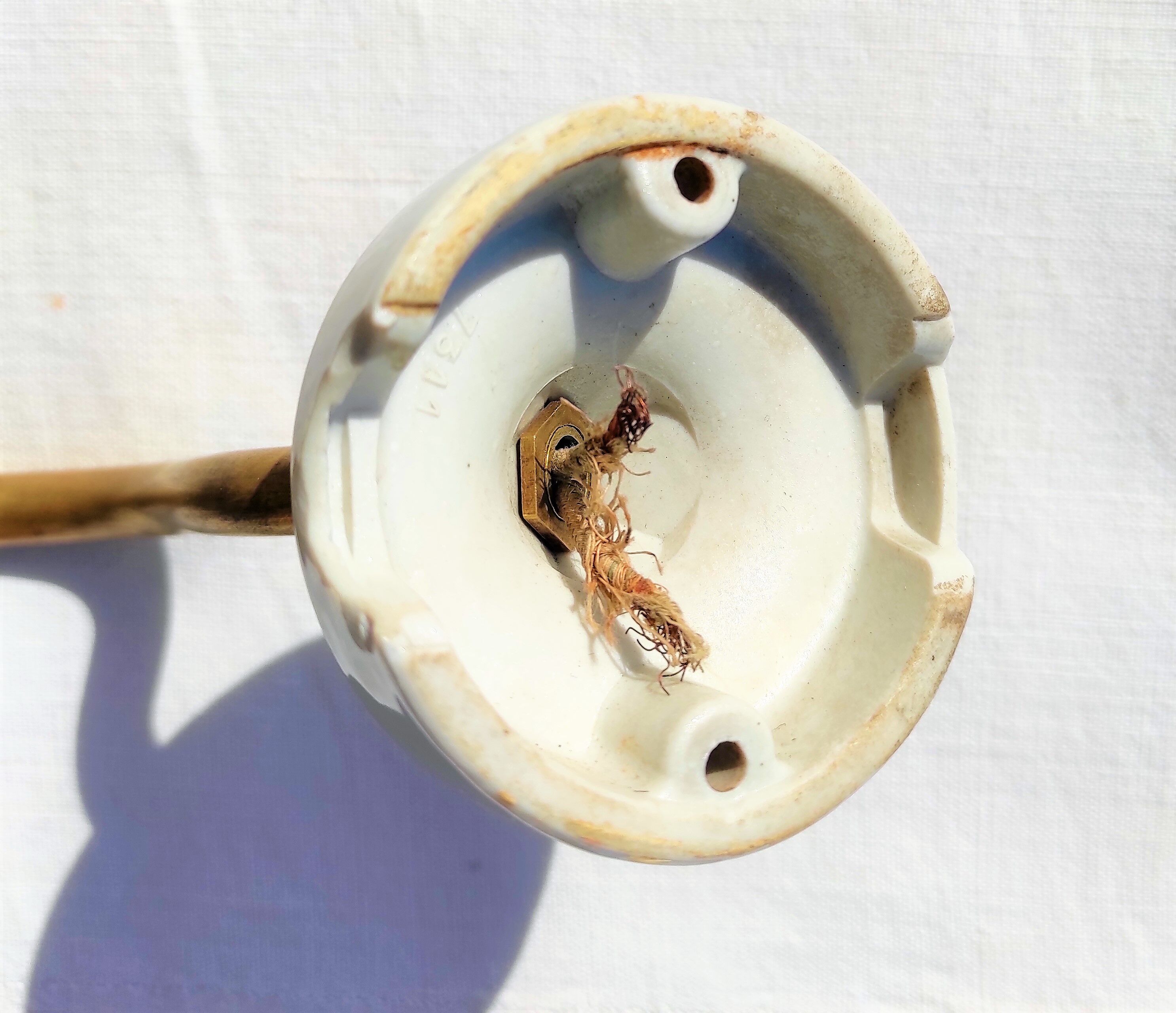 Brass gooseneck wall lamp, with brass socket and porcelain base.