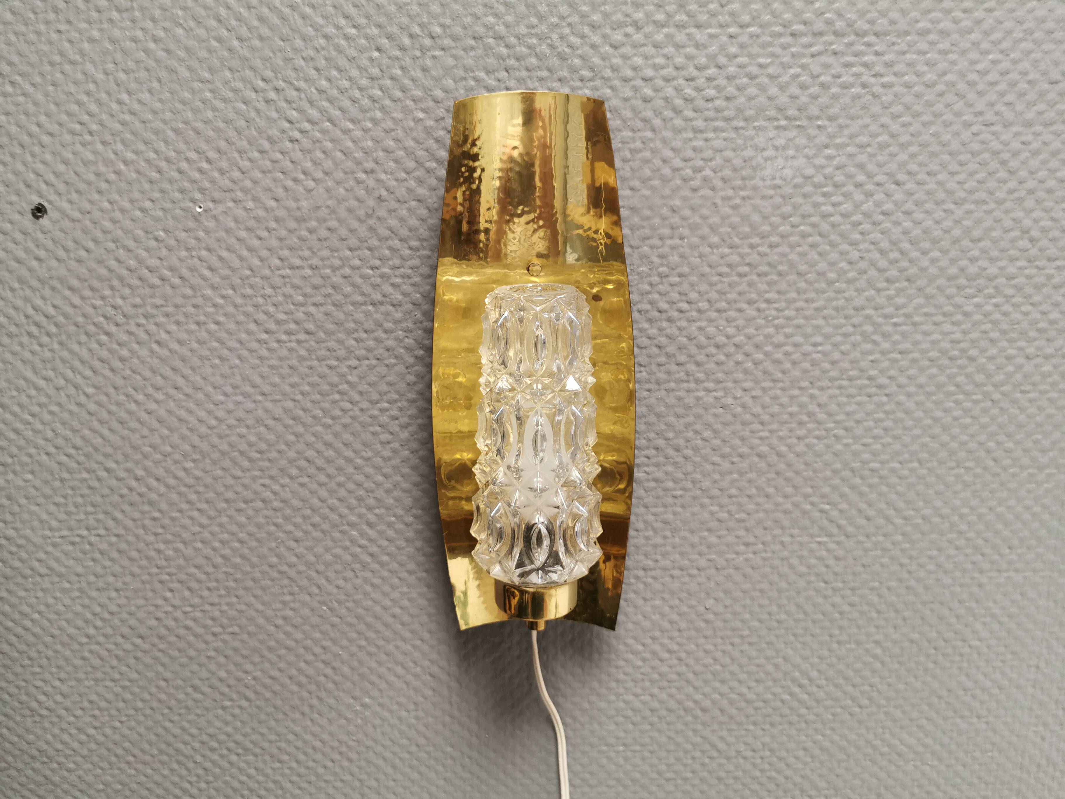 Older wall lamp in brass with hard pressed glass shade.