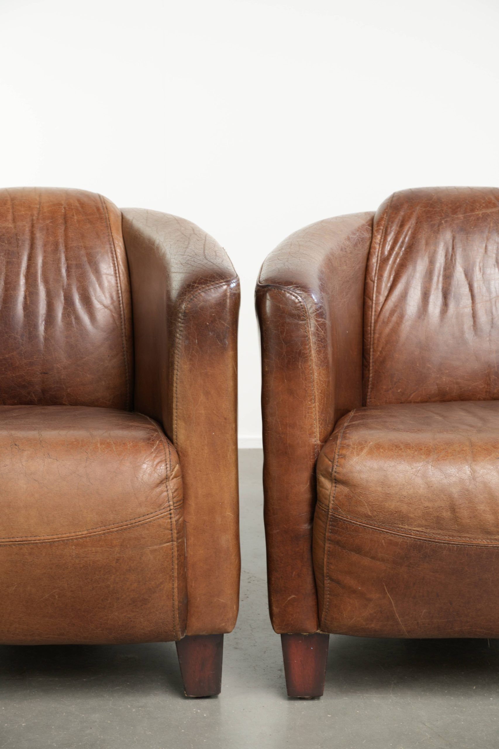 Ensemble de deux fauteuils aviateur vintage en cuir de vachette grainé.