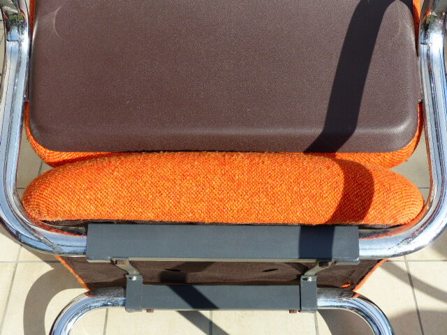 The 1970s orange armchair fabric and chrome metal