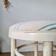 Vintage curved wooden stool in Baumann style, striped fabric seat.