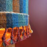 "Stoneware Bottle Lamp" with a multicoloured blue lampshade handwoven in India.