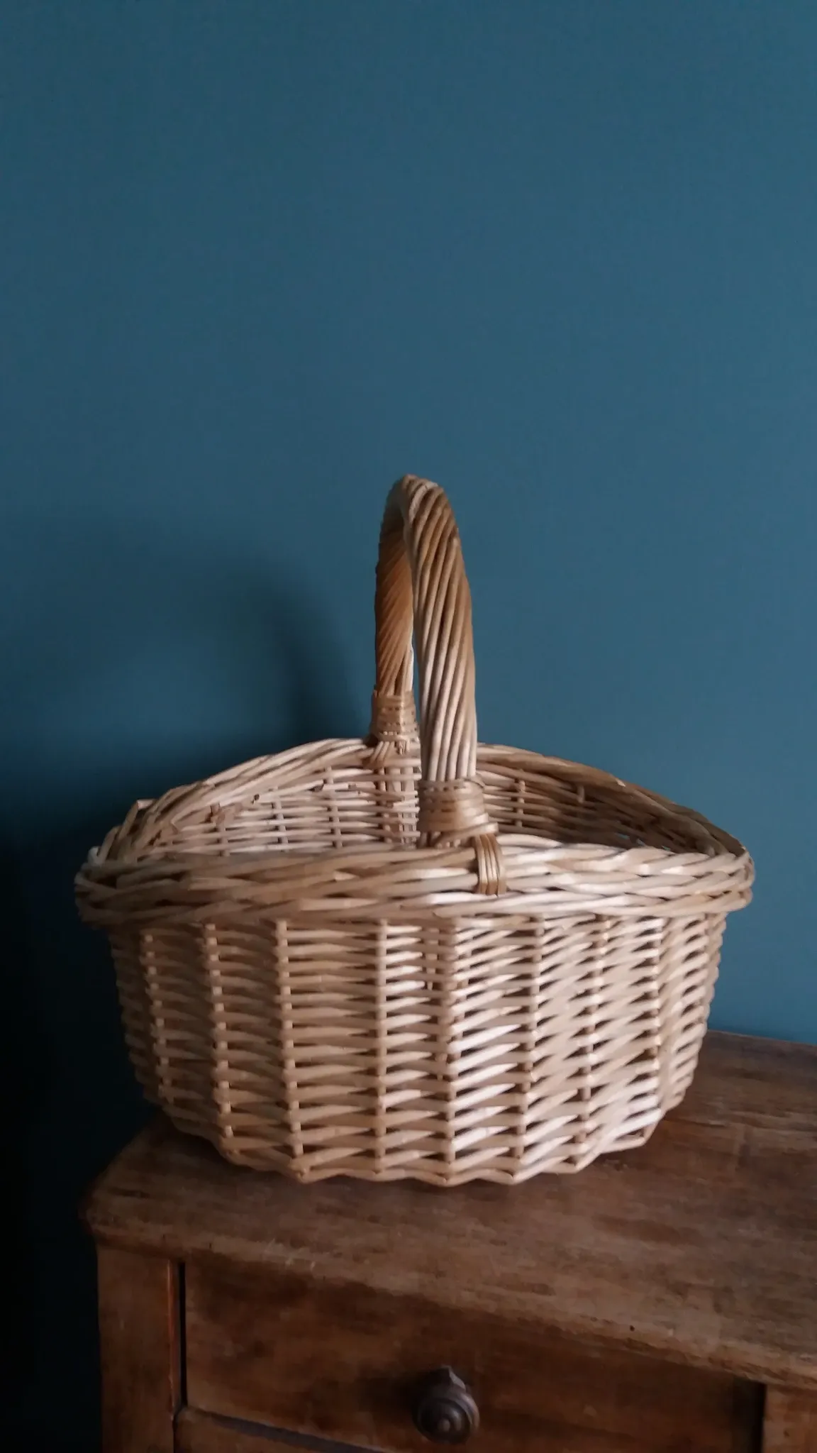 Handcrafted wicker basket with a handle.