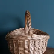 Handcrafted wicker basket with a handle.