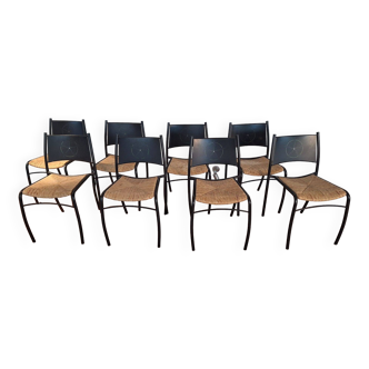 Suite de 8 chaises en métal laqué noir et assises en paille