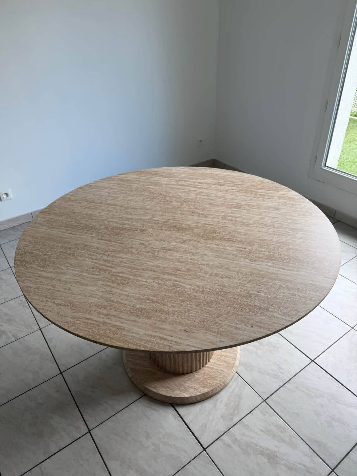 Round table with a travertine effect.