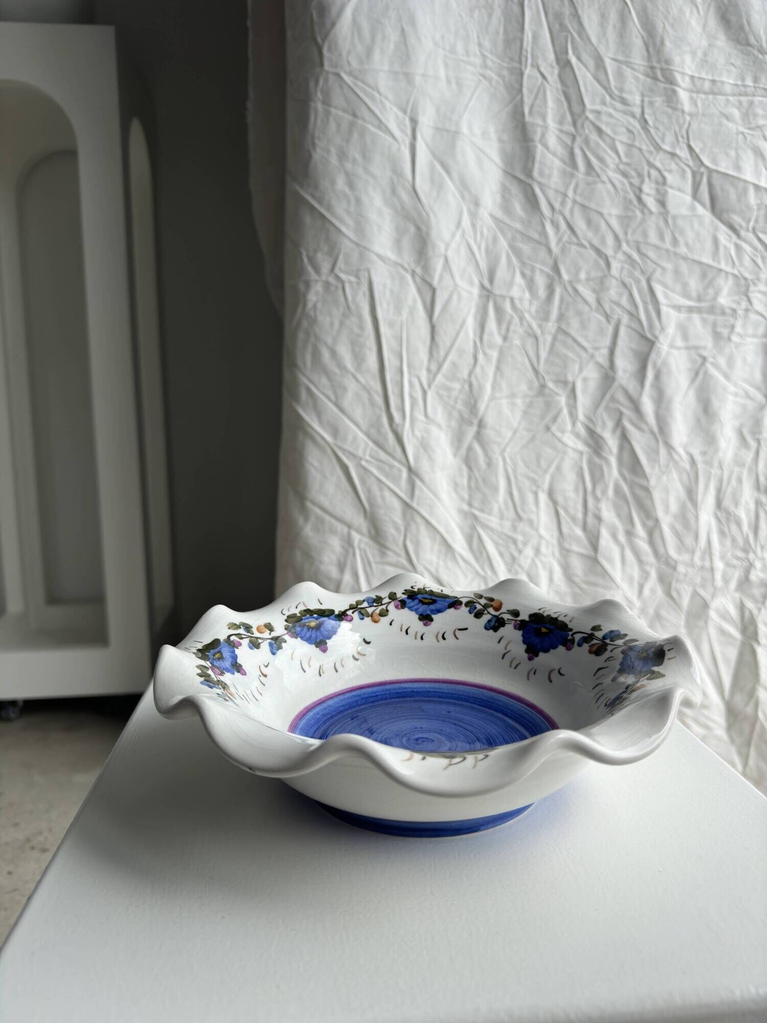 Small hand-painted earthenware salad bowl with garland of blue flowers, mark below