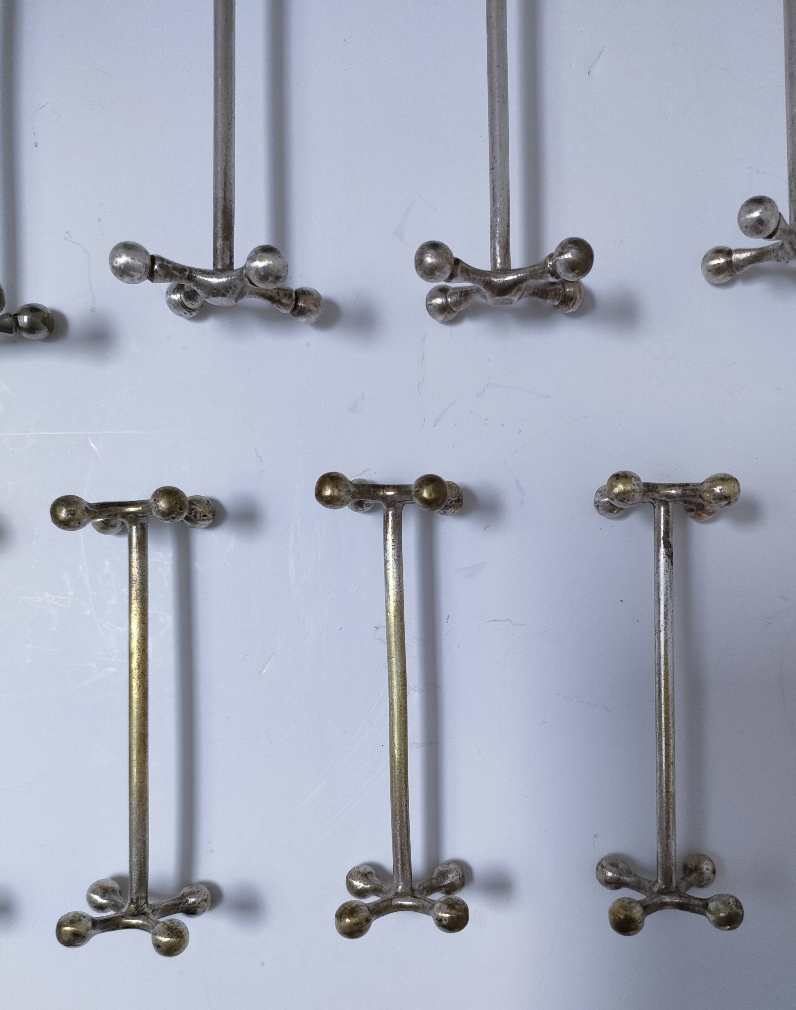 Eleven 70s design metal "crosshair" knife holders