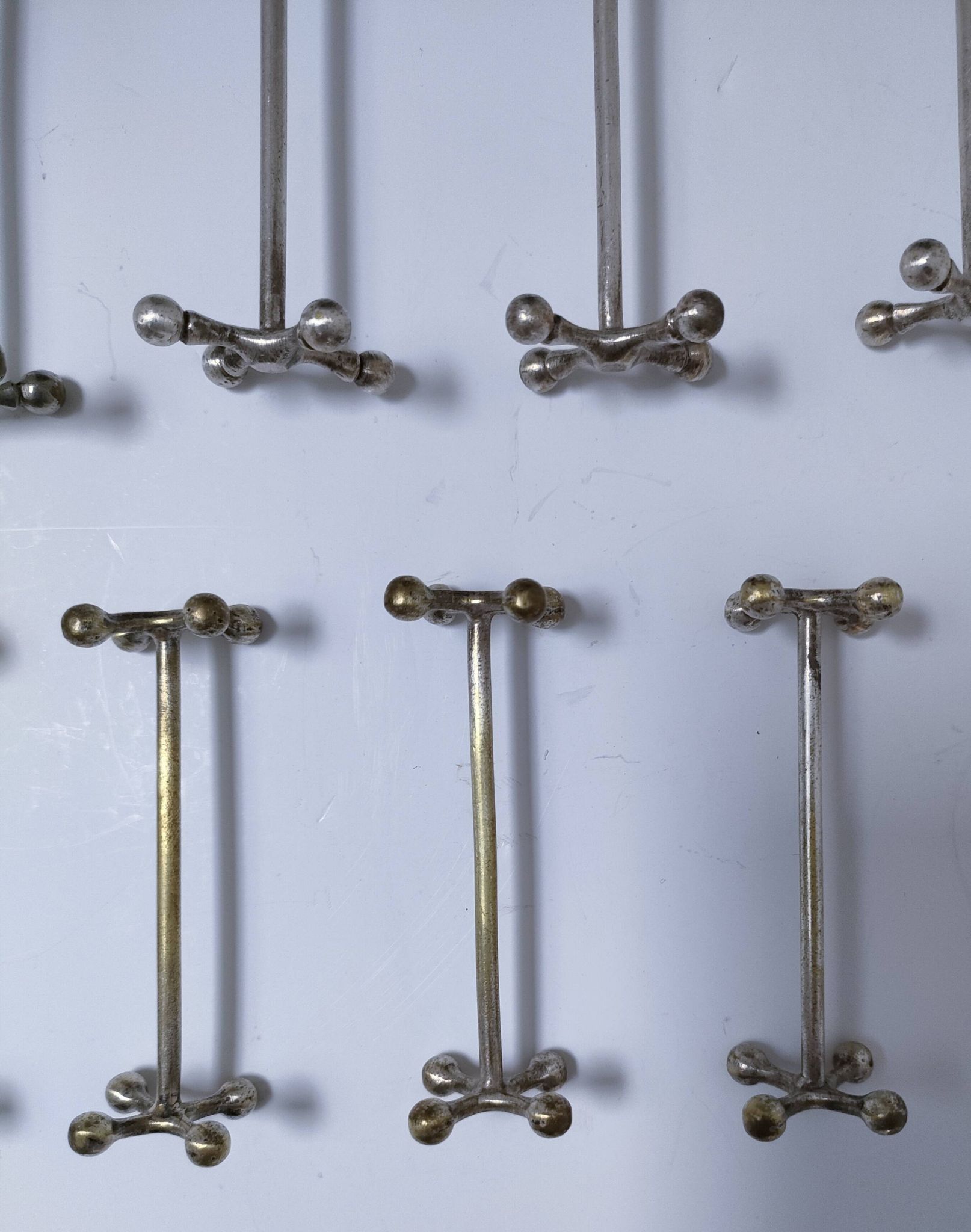 Eleven 70s design metal "crosshair" knife holders