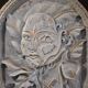 Bas-relief sculpture, stylized face with flowers, 20th century