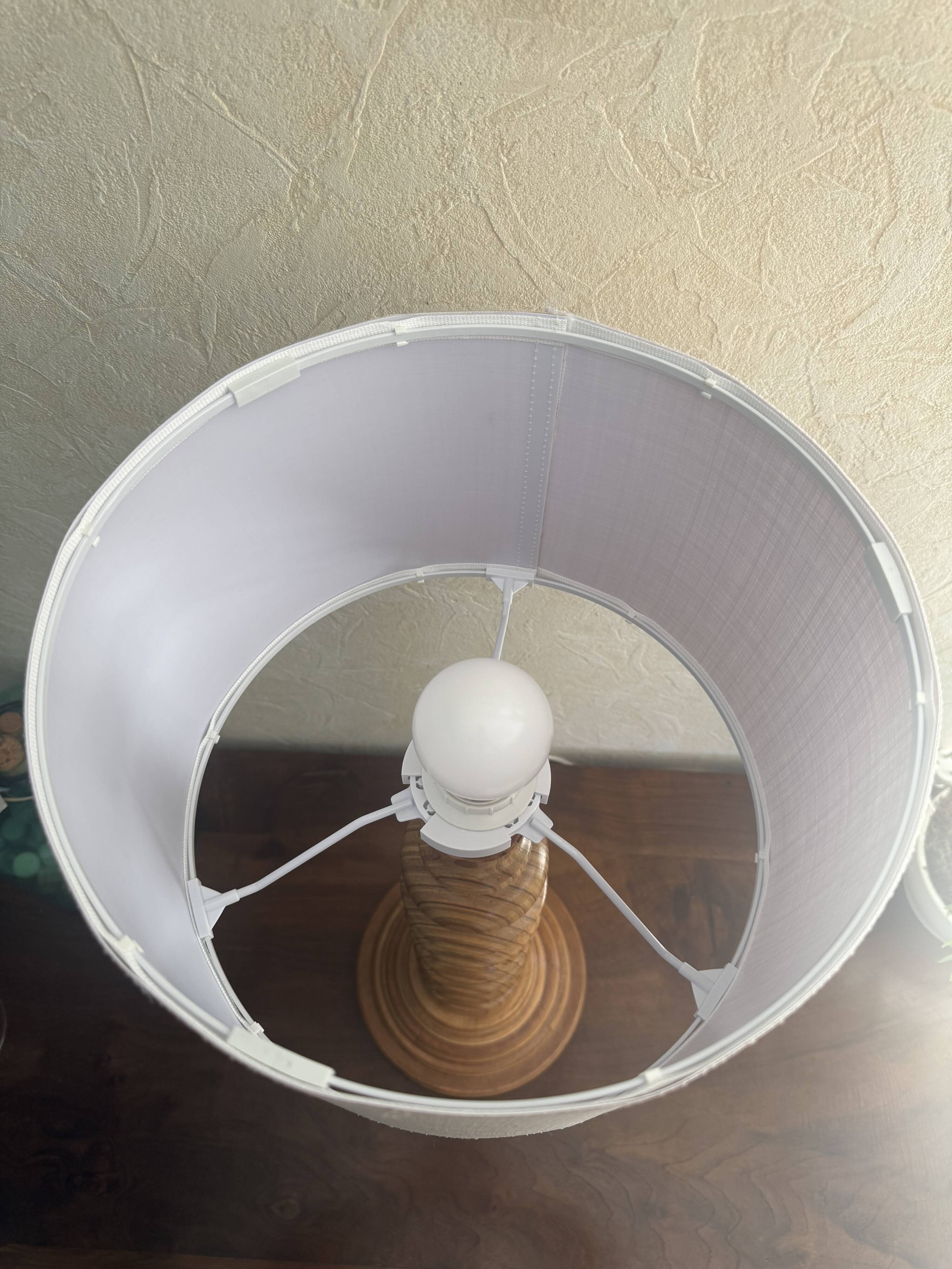Wooden turned totem lamp with a linen shade in a vintage Scandinavian style.