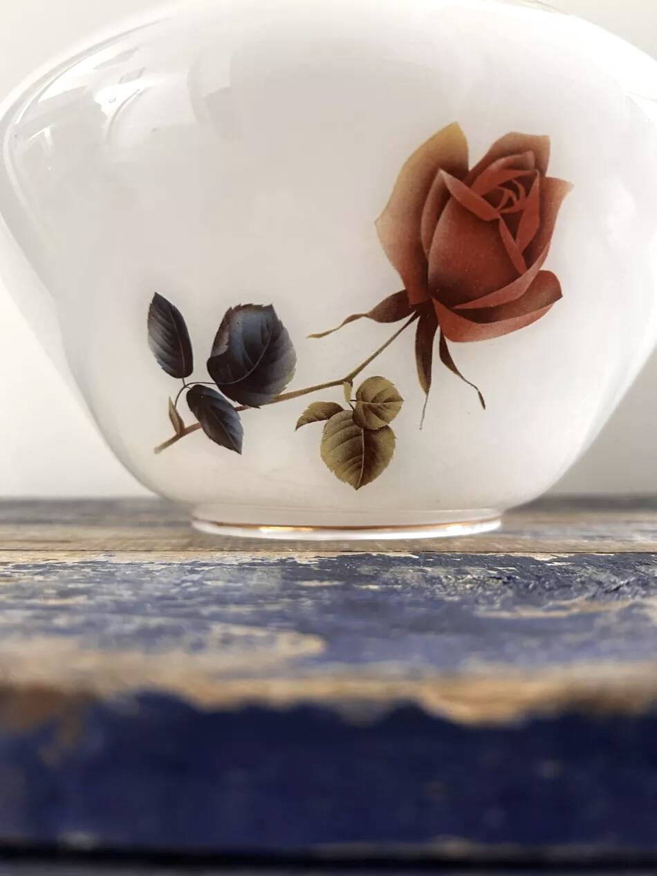 Golden tilting wall light with flowered globe