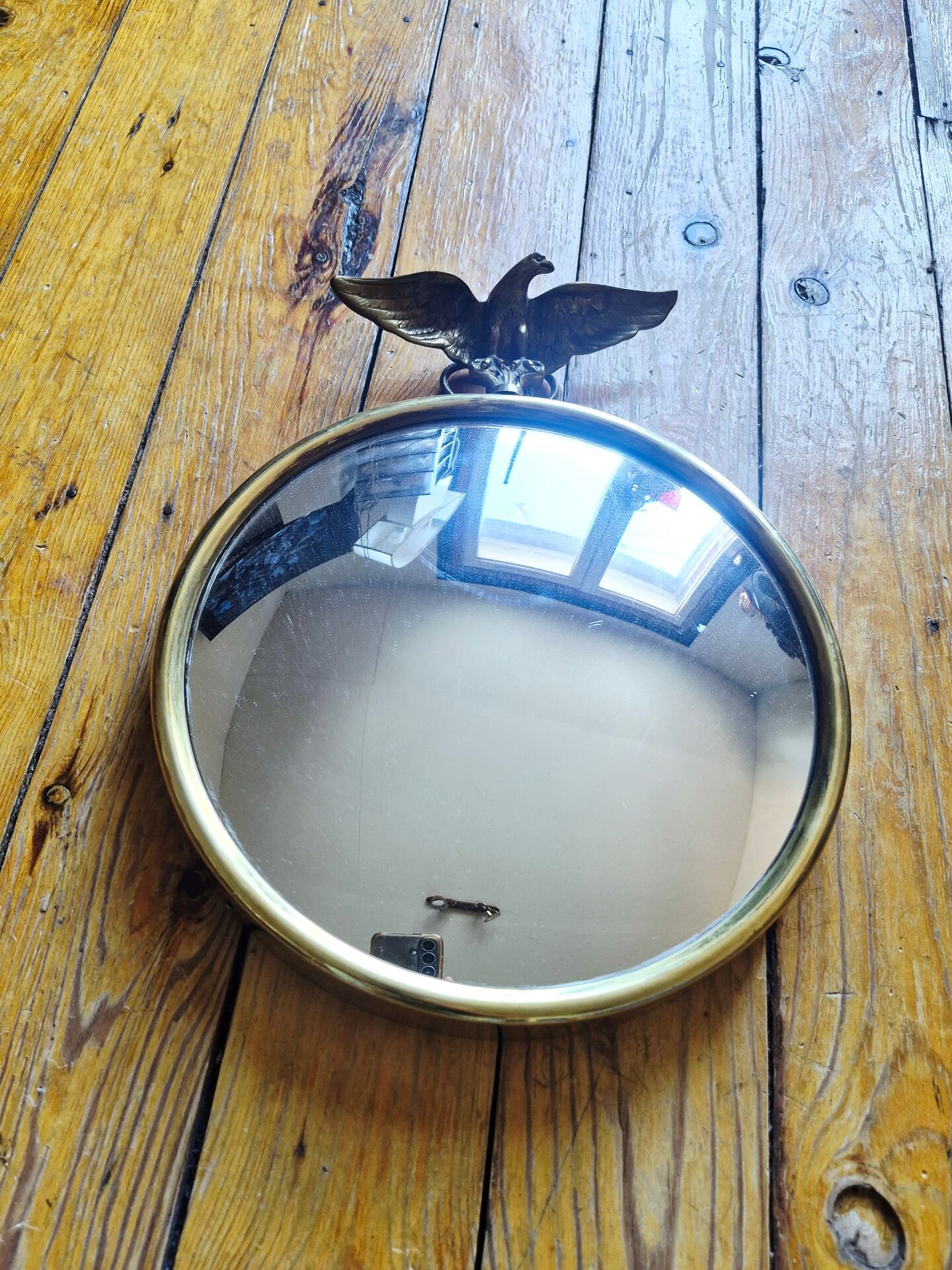 Vintage convex witch mirror with triumphant eagle.