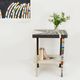 Table topped with a ceramic mosaic featuring an abstract design.