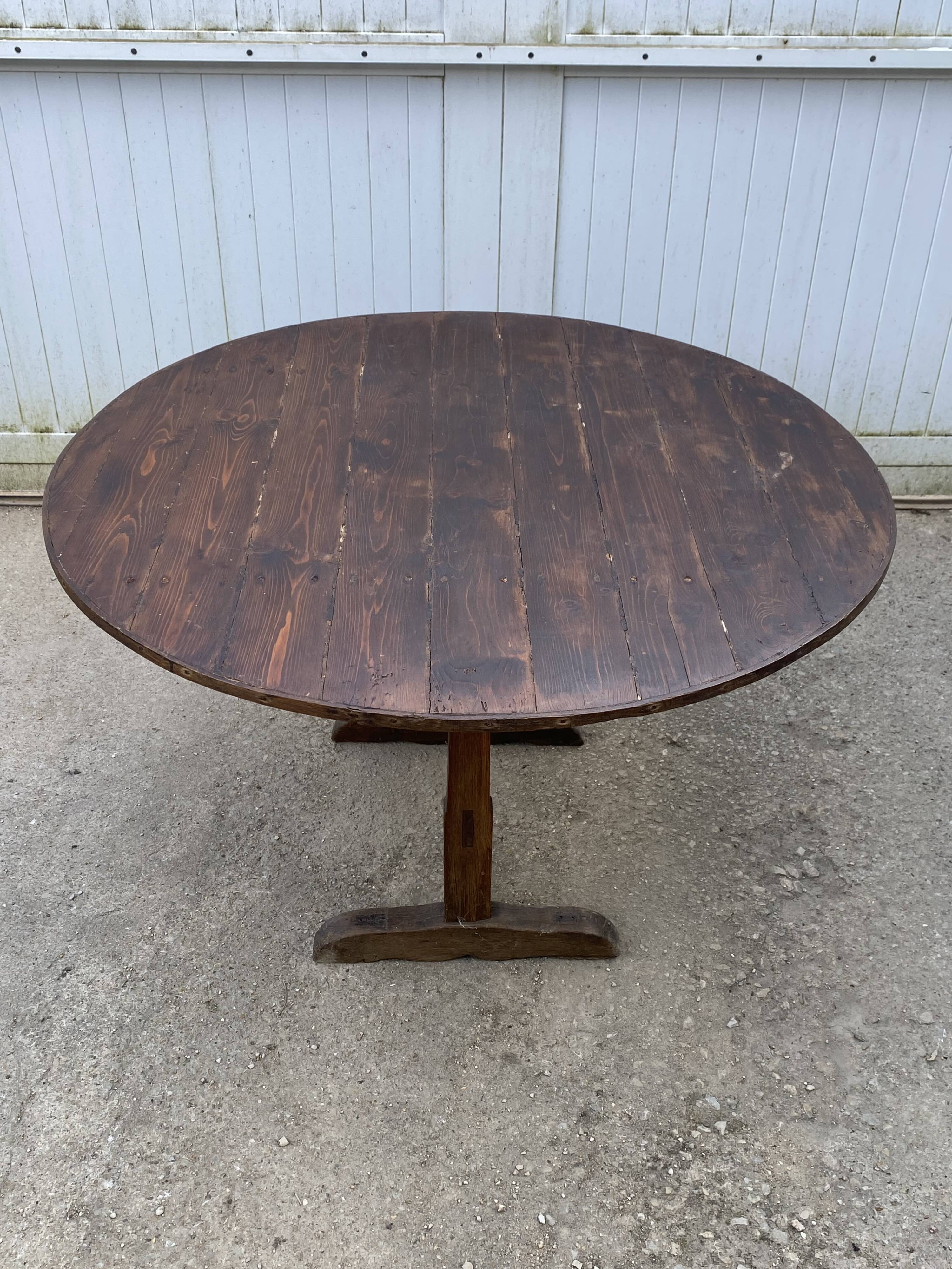 Old folding round winemaker's table with a tilting top.