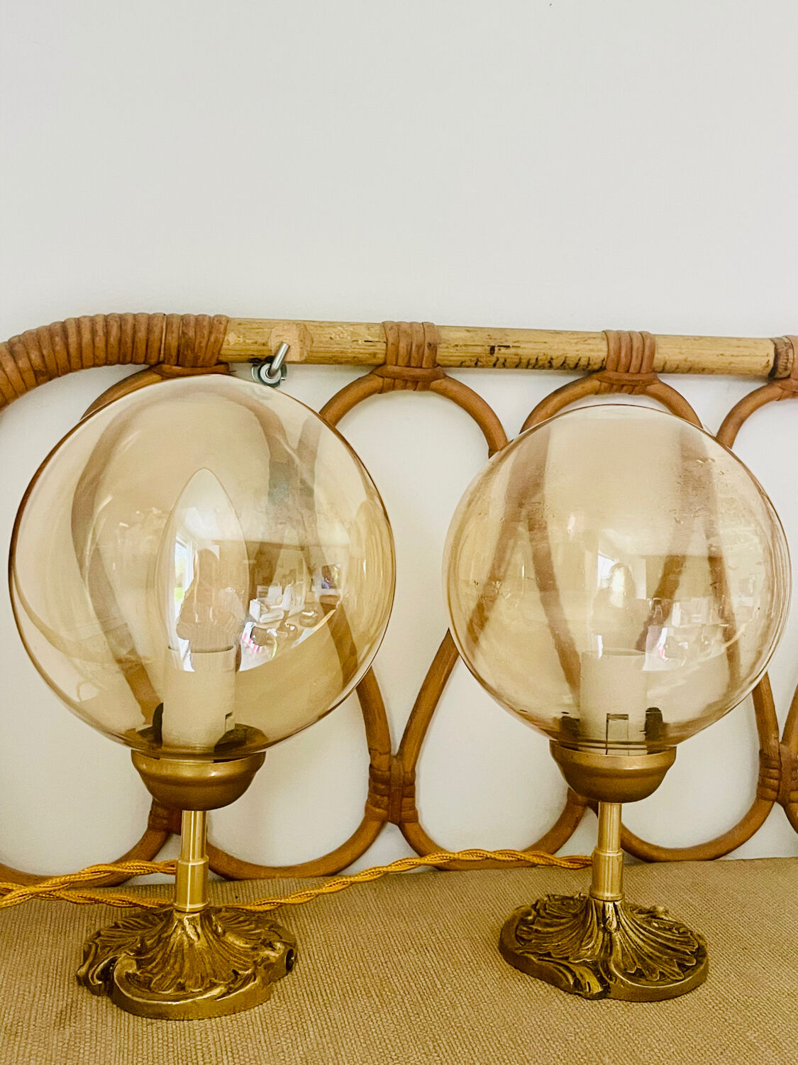 2 bedside lamps with round amber glass globes and gold metal.
