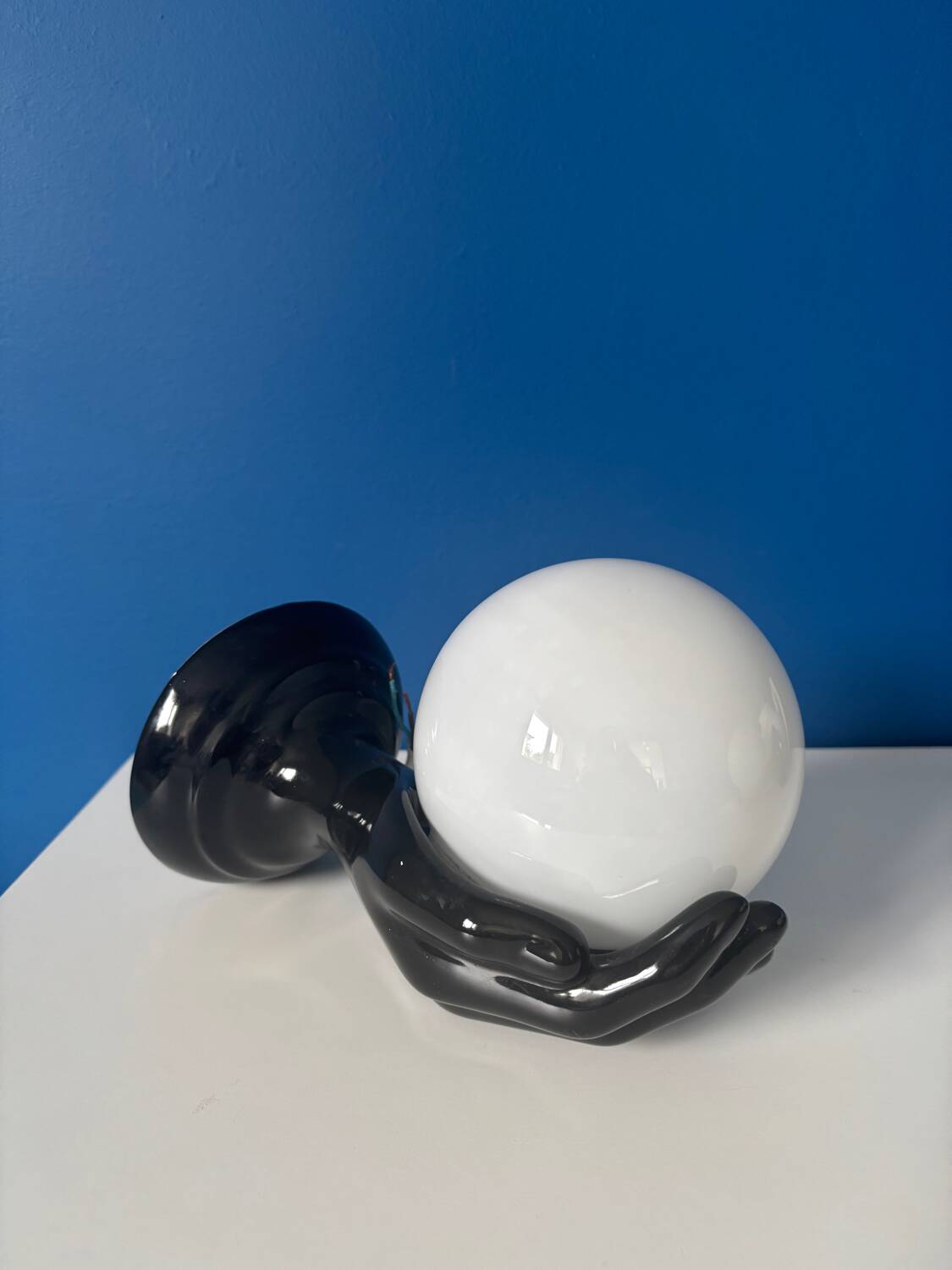 Vintage wall sconce with black hand and white opaline glass globe, 1970s L