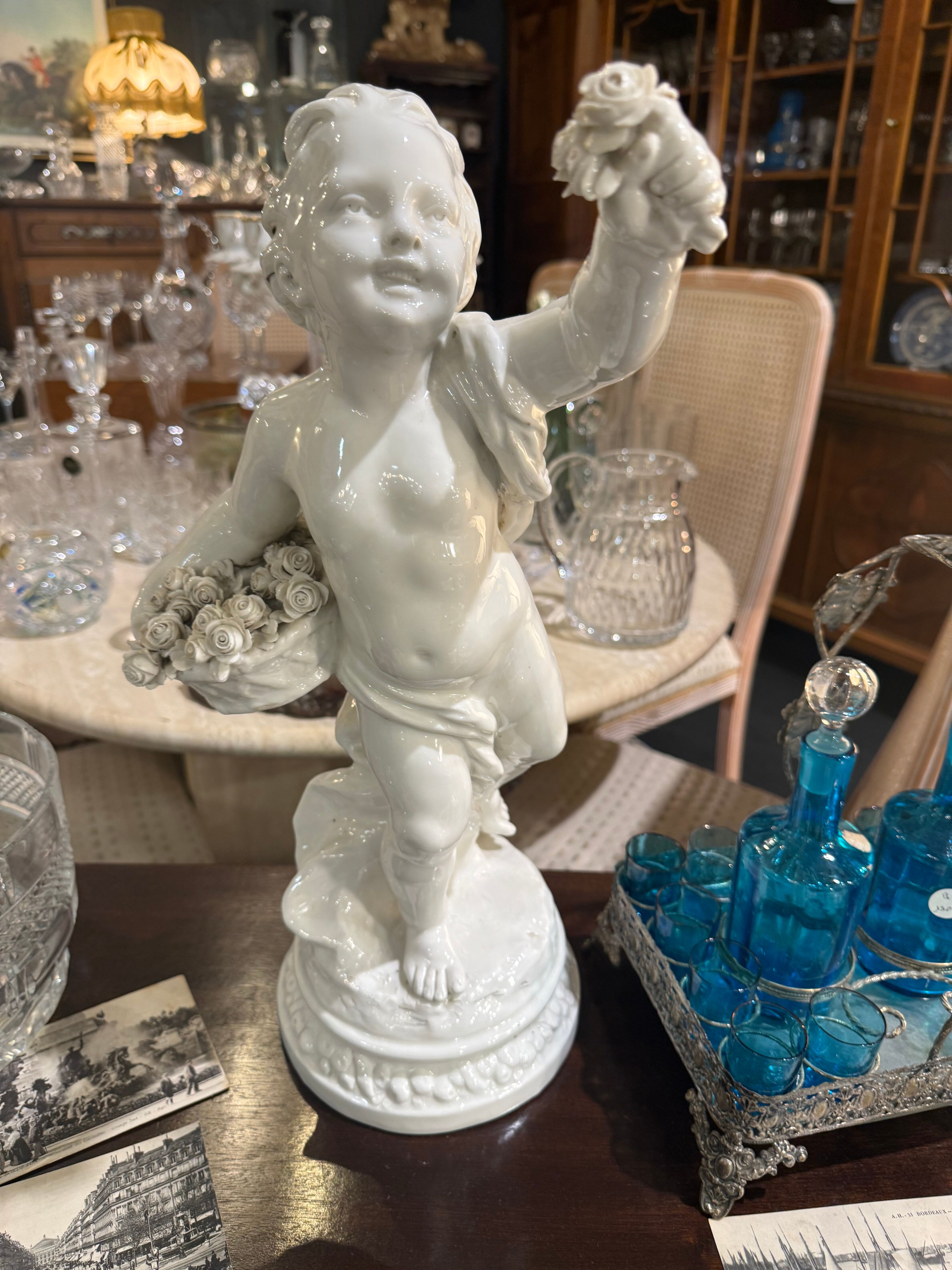 Child statue with flowers in porcelain, signed.