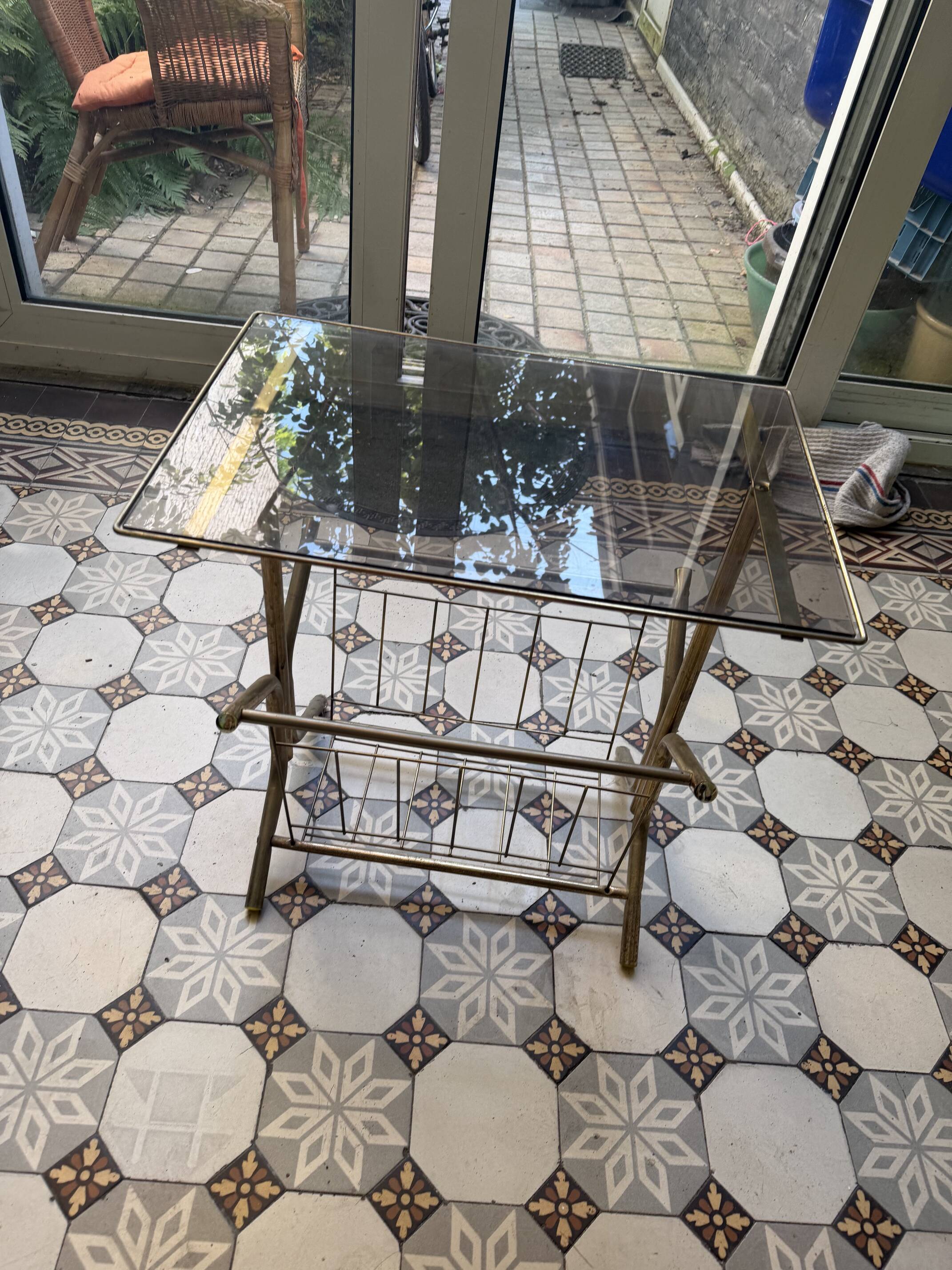 Vintage style side table with magazine holder, gold metal and glass top.