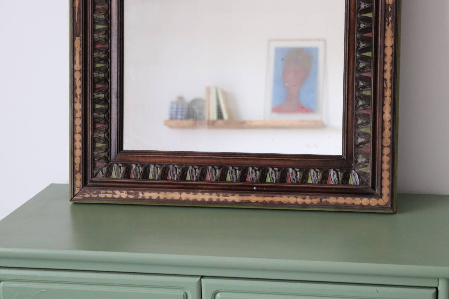 Antique mirror with a carved and painted wooden frame