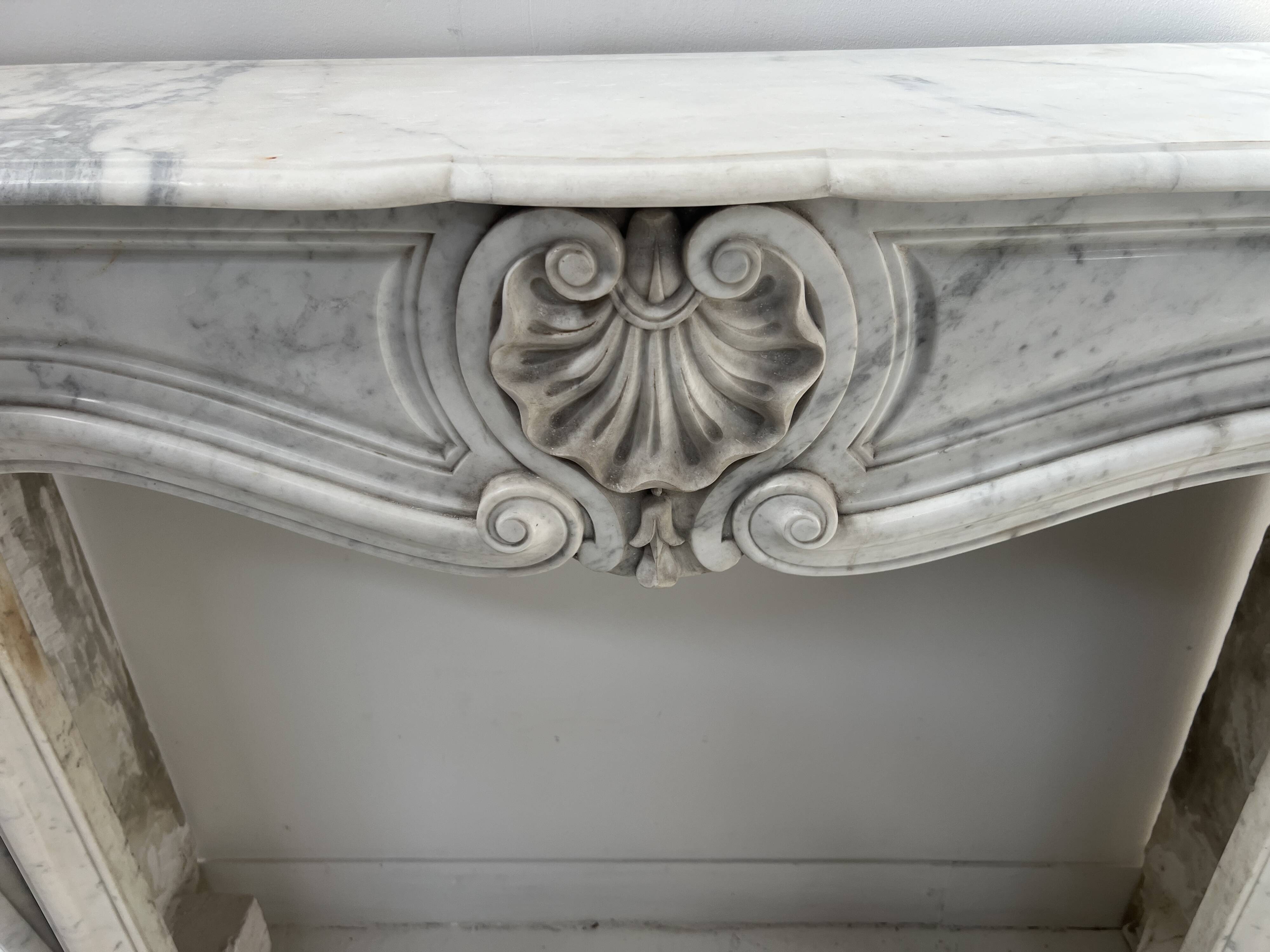 Louis XV style fireplace in veined white Carrara marble, 19th century.