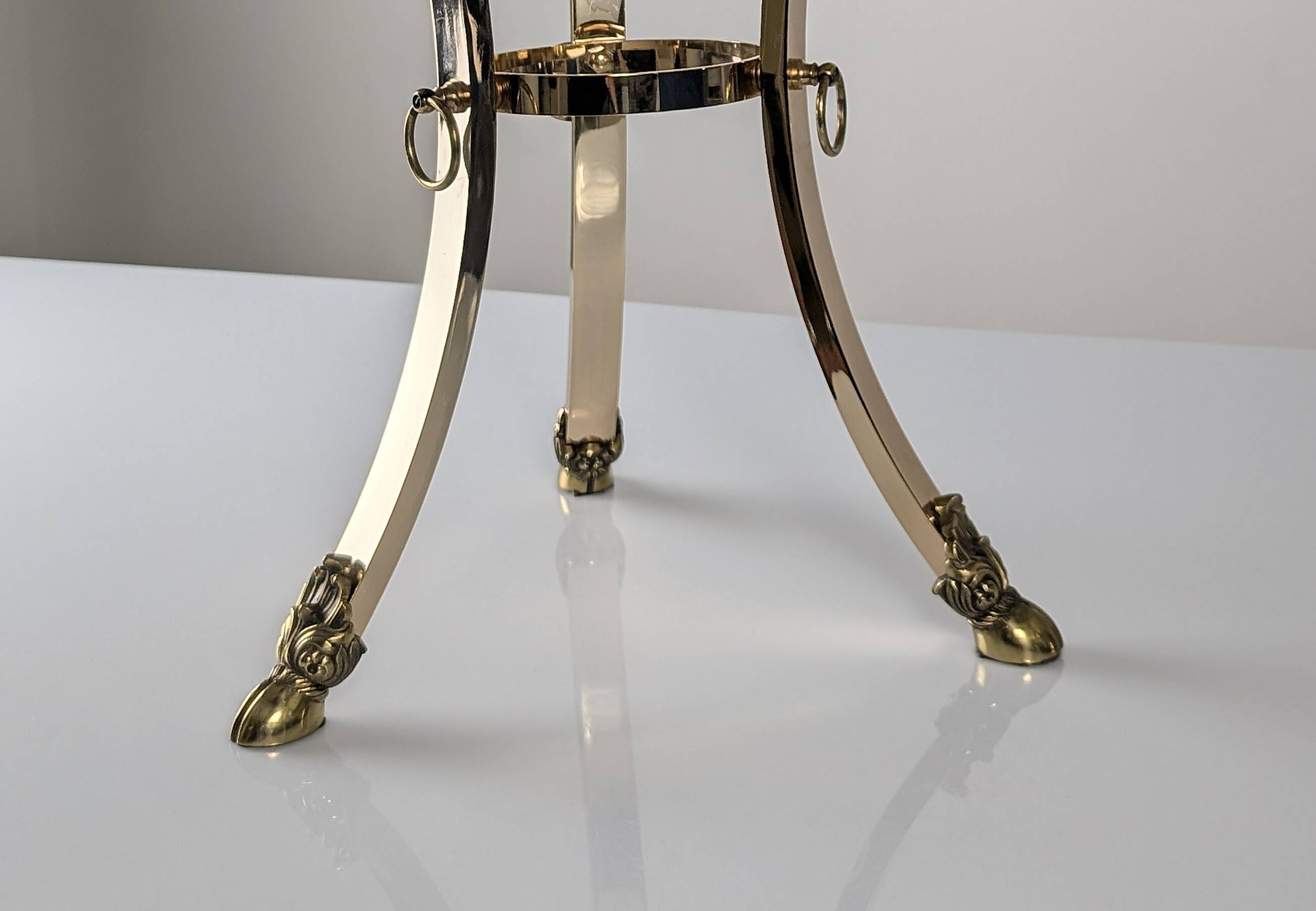 Neoclassical side table in brass and bevelled glass with ram's heads, 1970s.