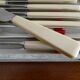 12 vintage stainless steel knives bone or bakelite sleeves in case