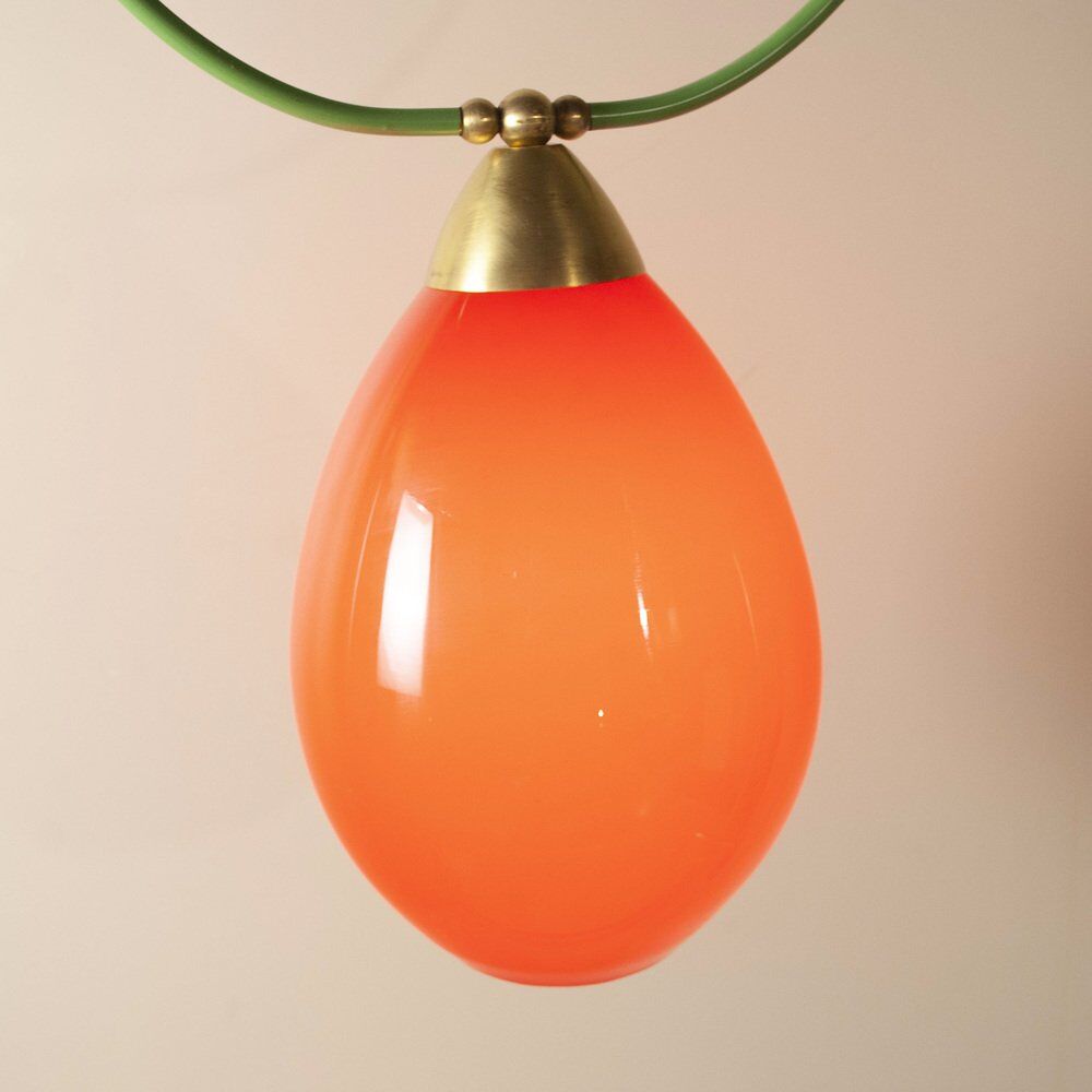 Hanging lamp with a brass frame in the shape of scales and a red-purple Murano glass diffuser.