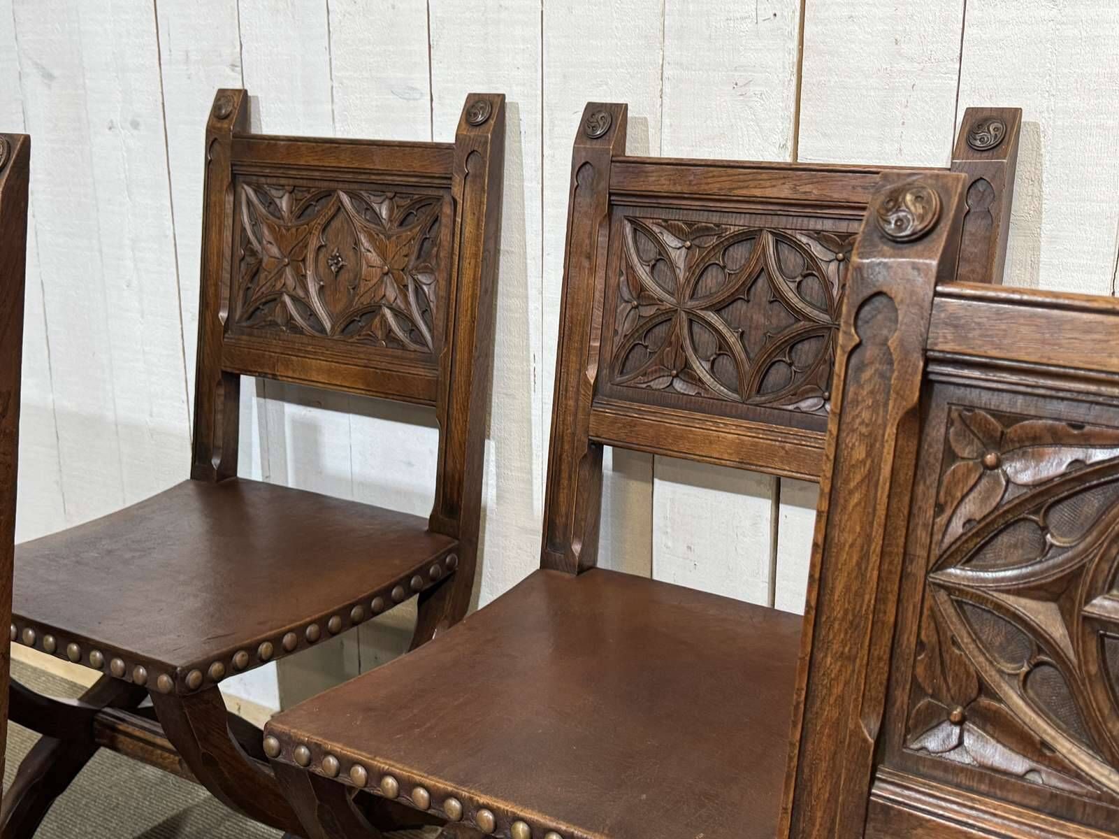 Suite de 6 chaises et 2 fauteuils en chêne et cuir à décor gothique