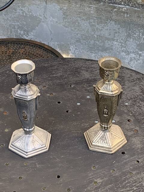 Pair of metal candlesticks, chiseled with a statuette in front, rose pattern in relief, art deco