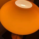Table lamp with a vintage orange glass globe saucer and a gold base