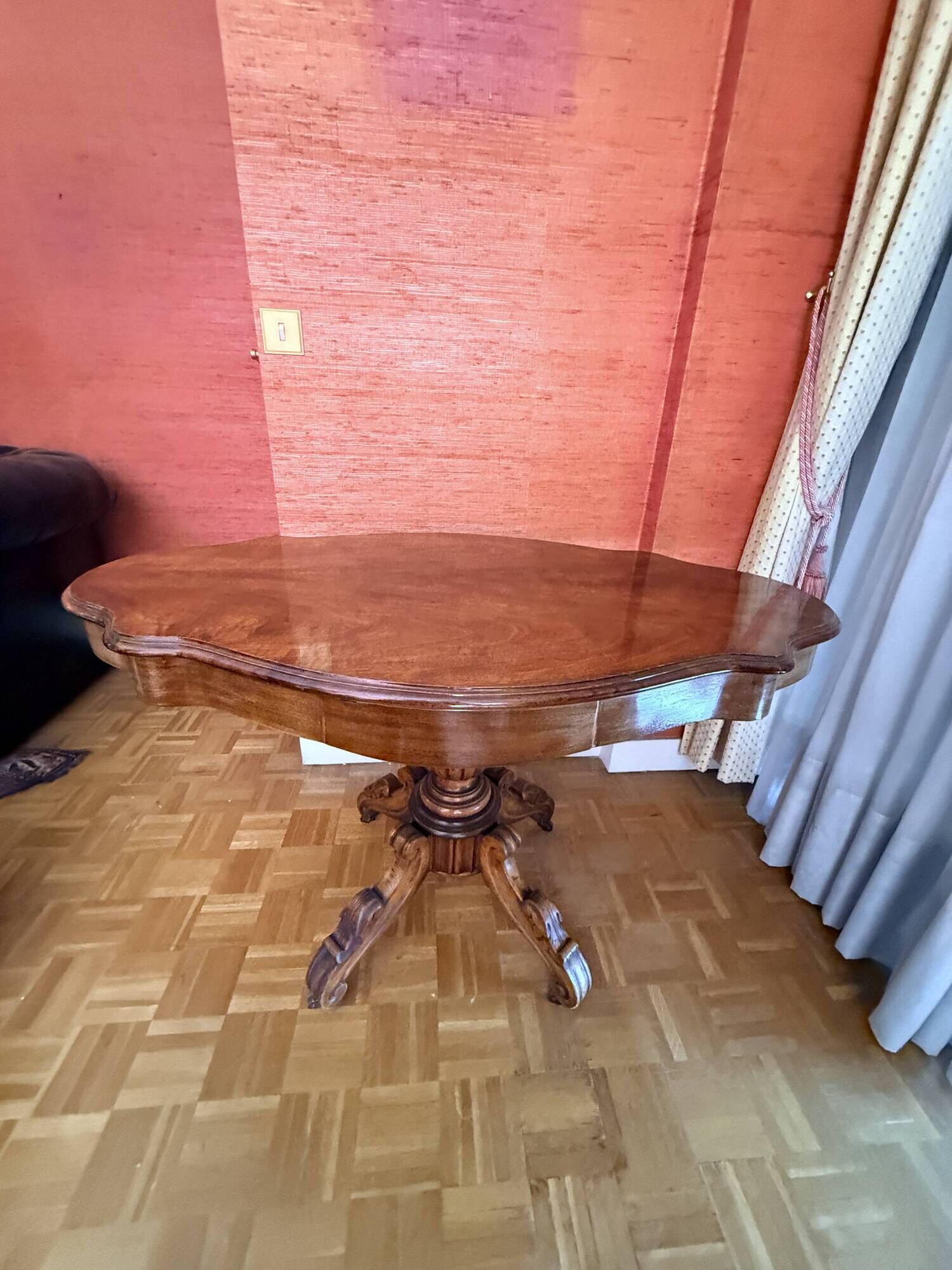 Antique mahogany table with a scalloped top and a sculpted central leg.