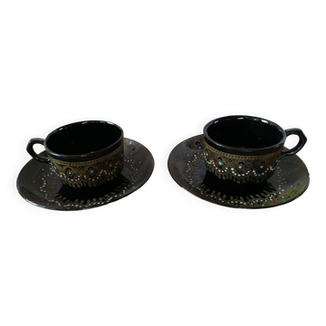 Black cups and saucers with relief decoration