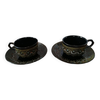 Black cups and saucers with relief decoration