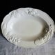 Oval white vegetable dish, an antique tableware piece in barbotine earthenware.