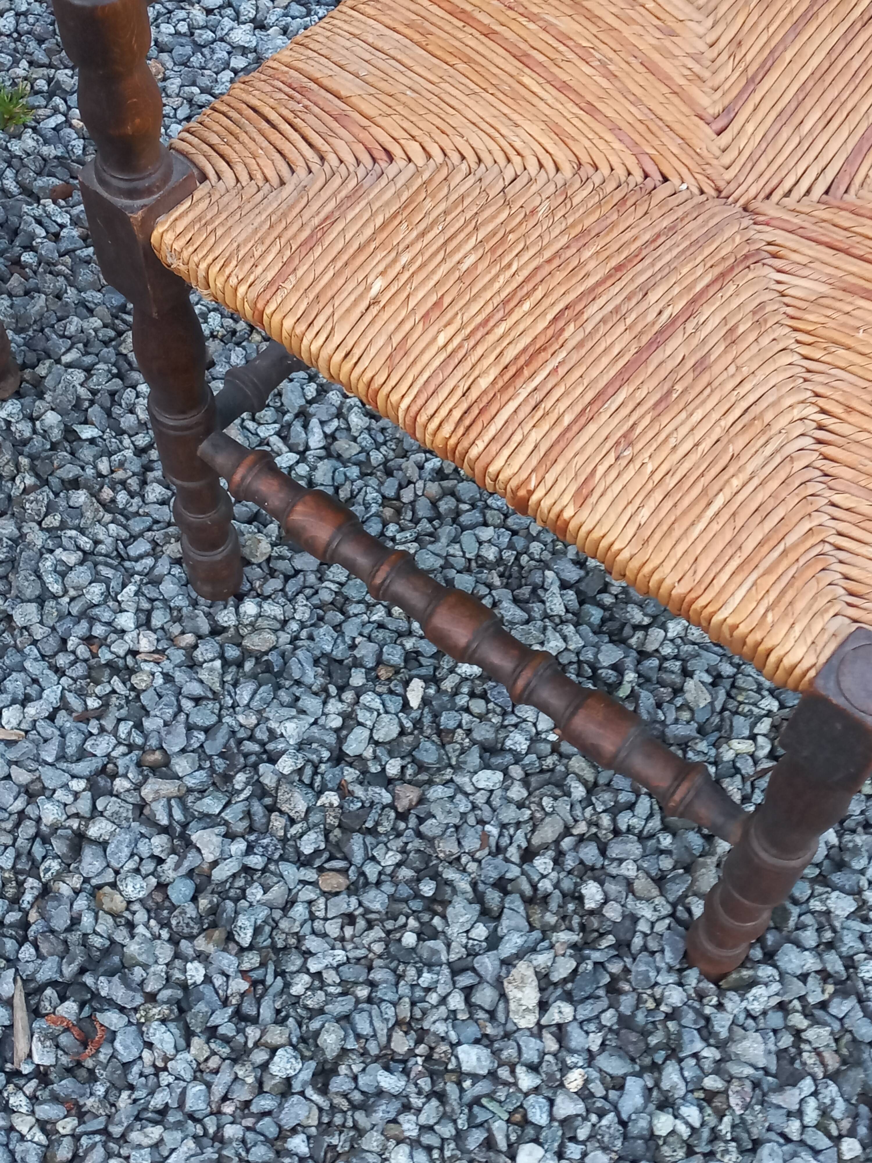 Pair of angled armchairs with turned wood and rush seats from the 1960s.