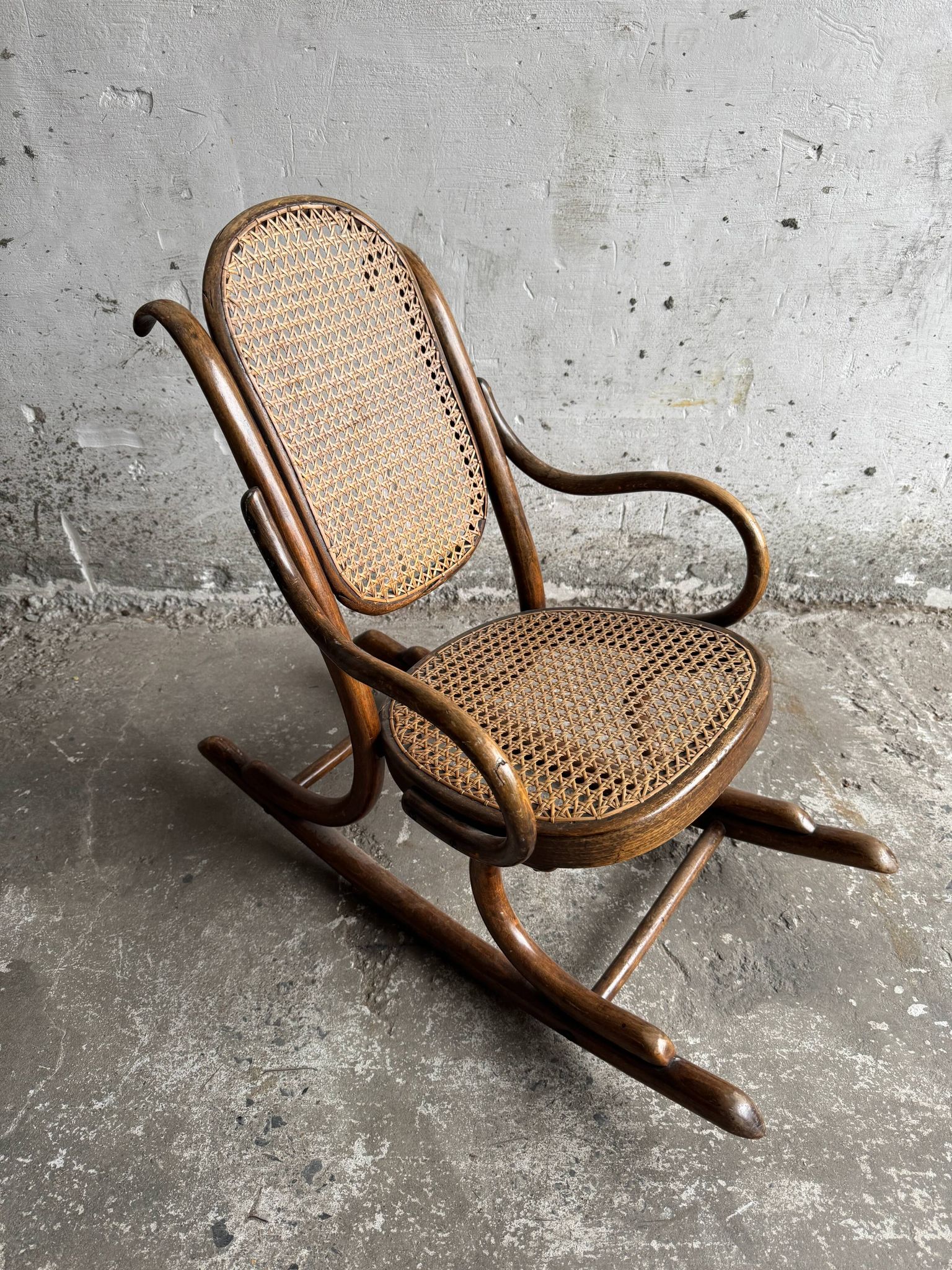 Warm walnut bentwood and cane child's rocking chair early 20th-century