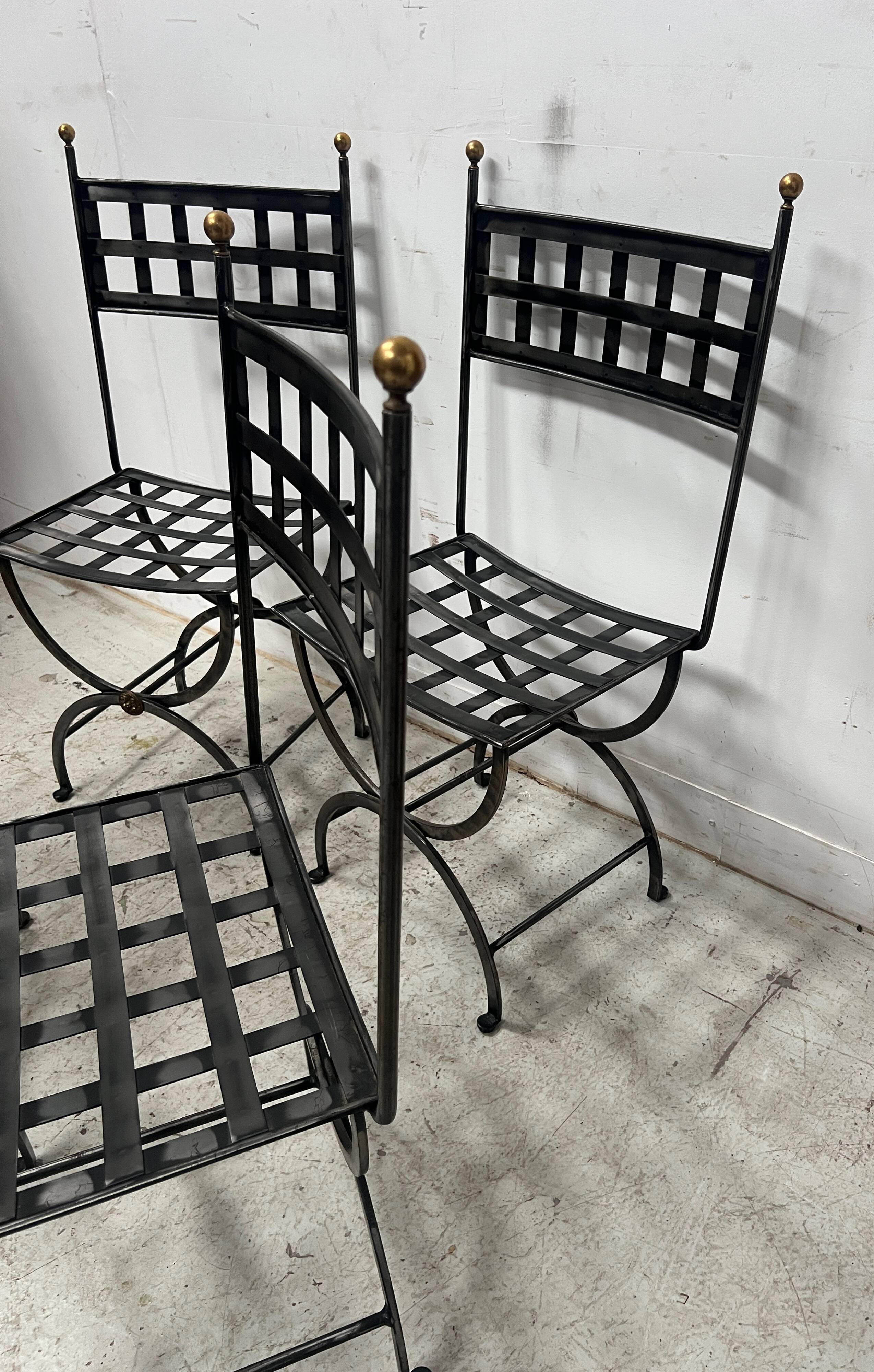 Set of four wrought iron chairs, with a reclining X-shaped base, seat and backrest.