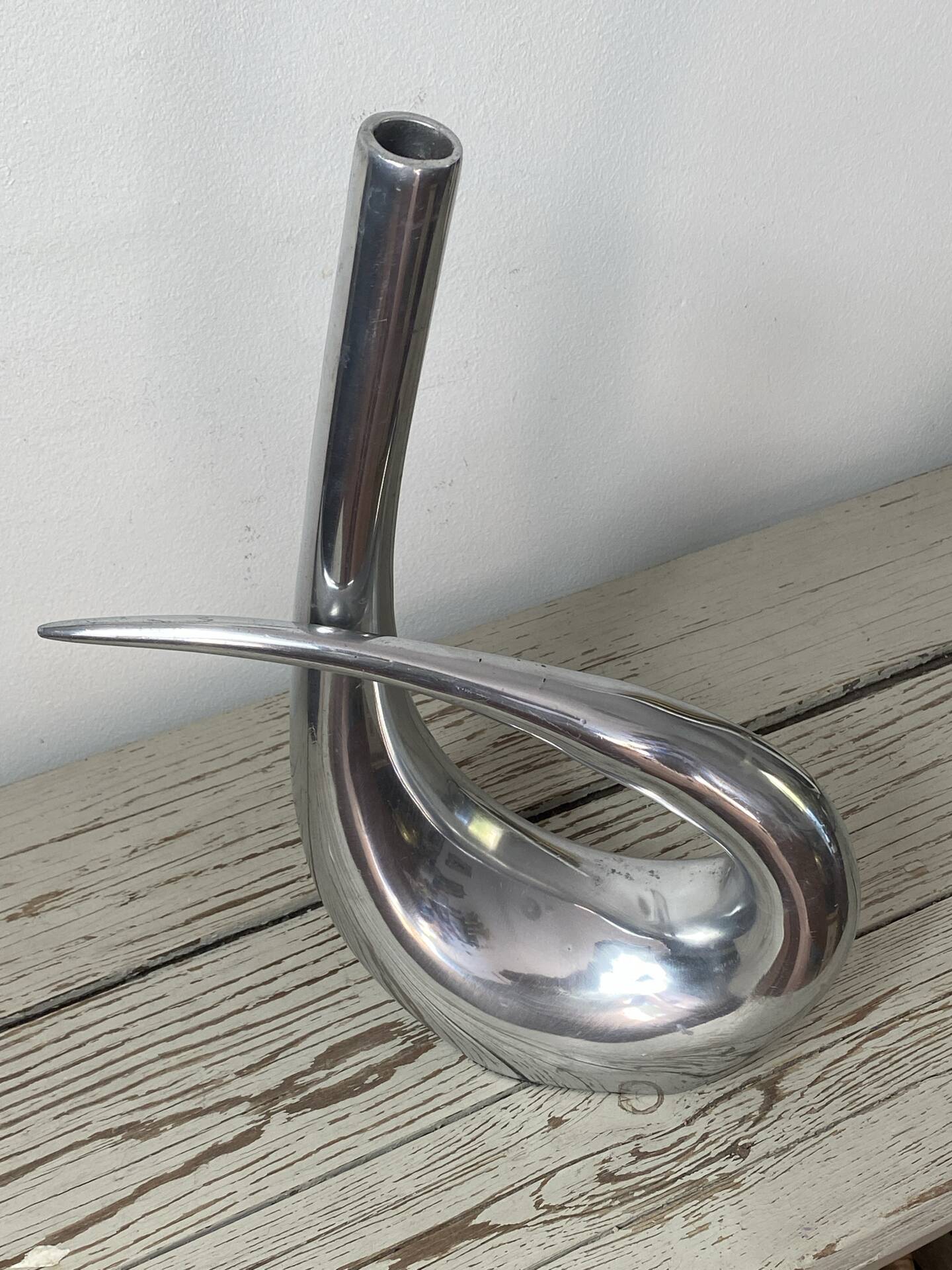 Sculptural vase design in polished aluminium.