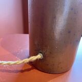 "Stoneware Bottle Lamp" with a multicoloured blue lampshade handwoven in India.