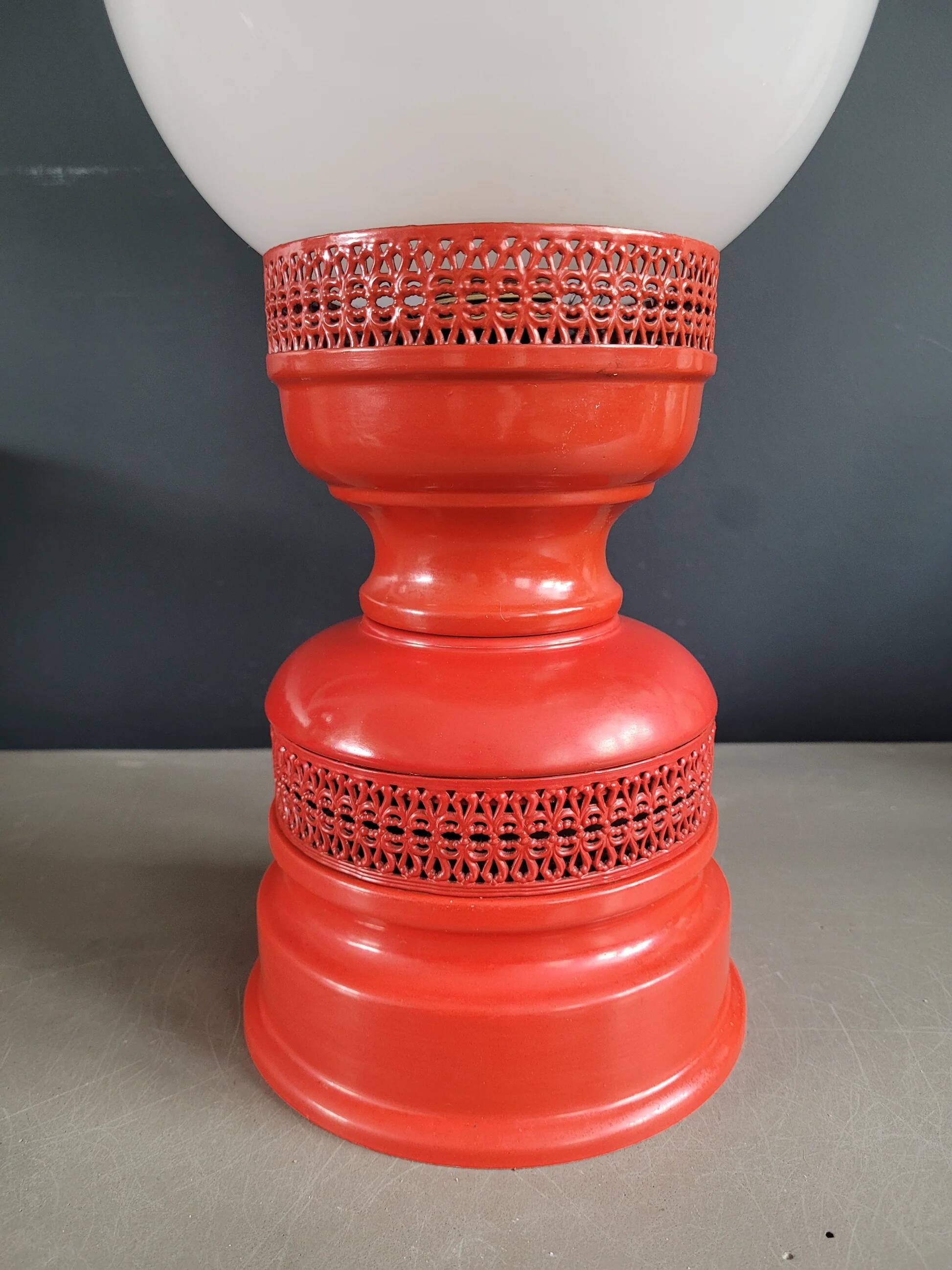 Vintage globe lamp with a metal base, perforated and lacquered in red.