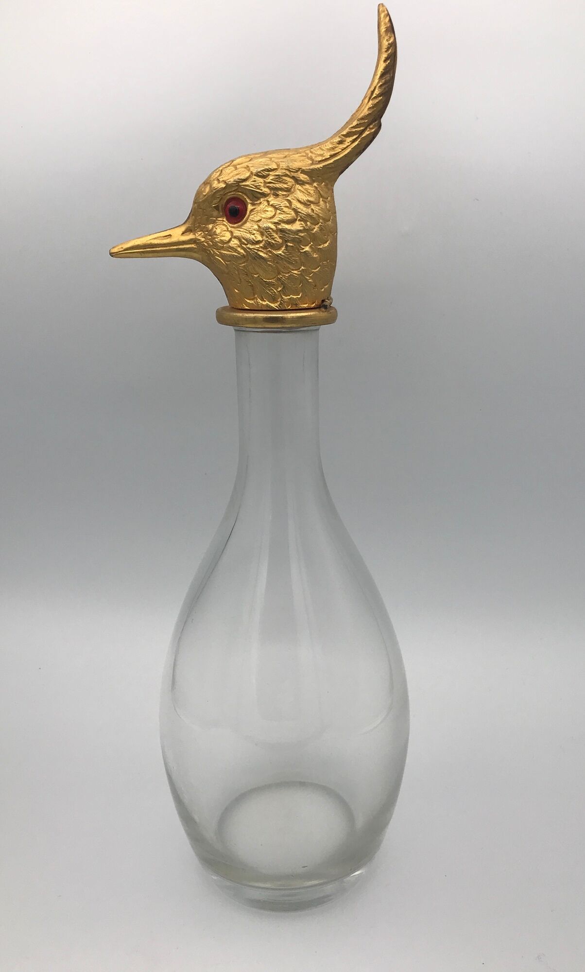 Glass bottle type carafe with gold metal bird head stopper