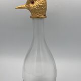 Glass bottle type carafe with gold metal bird head stopper