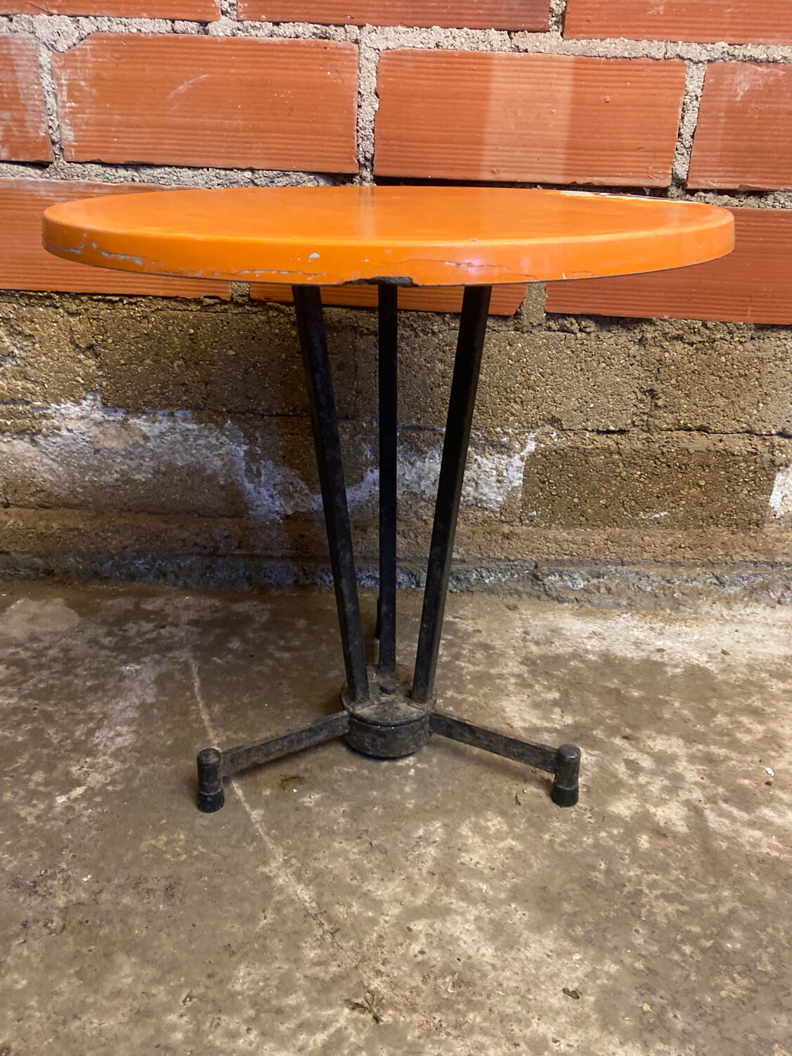 Vintage bistro table with black cast iron base and orange bakelite top, 1950s