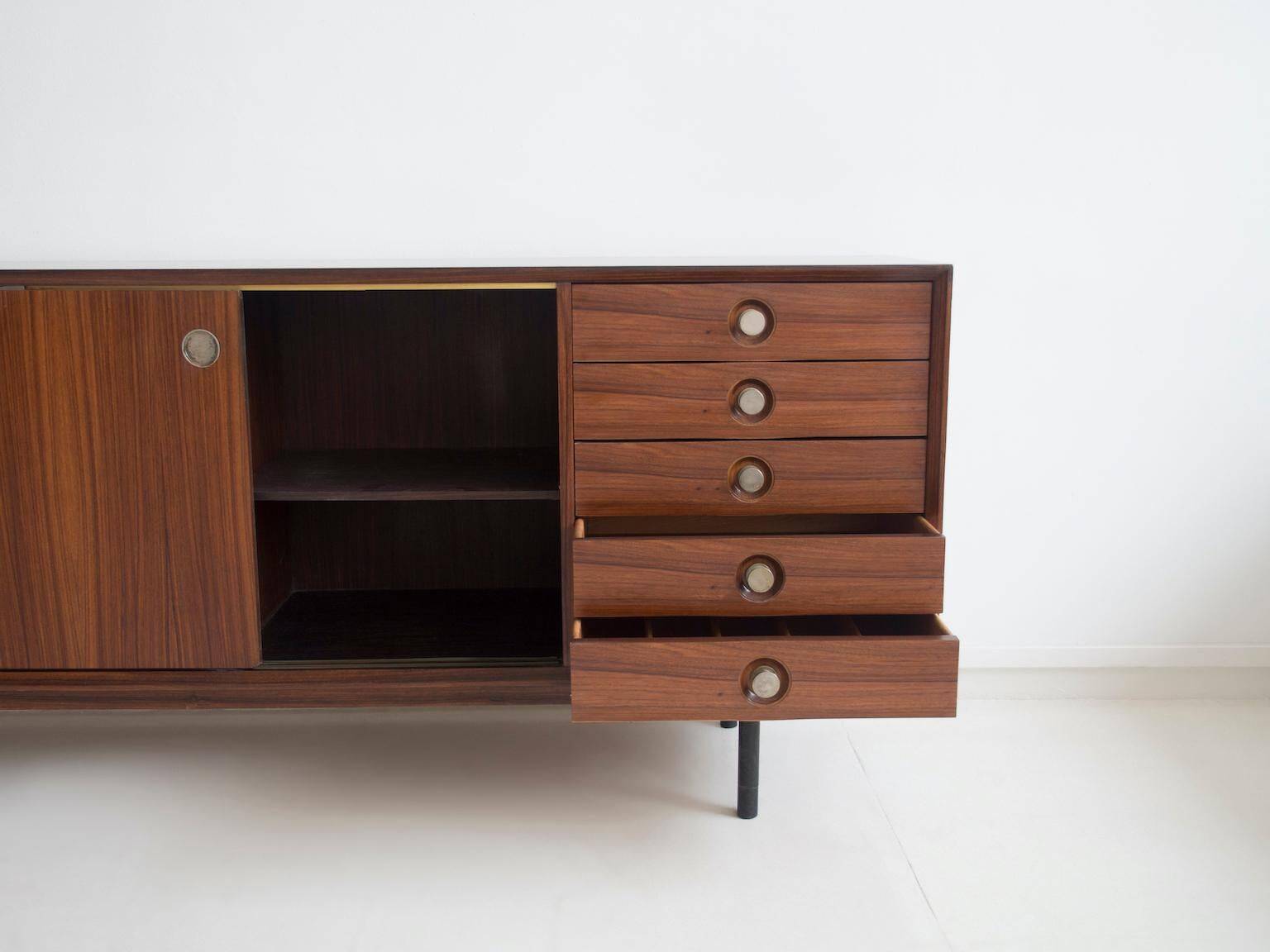 Wooden sideboard with sliding door and white drawers, around 1960.