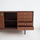 Wooden sideboard with sliding door and white drawers, around 1960.